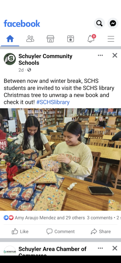 Seniors%2C+Niurka+Castro+and+Kathryn+Tzunux+unwrapping+their+gifts+in+the+library.+